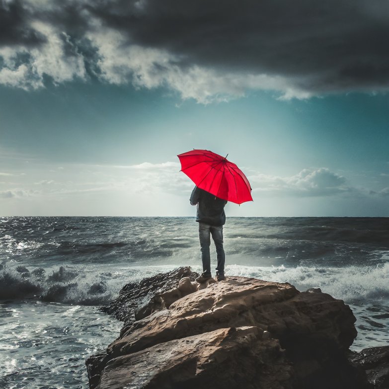 firefly_young_man_with_red_umbrella_looking_towards_the_horizon_on_a_rock_in_the_open_stormy_sea_318.jpg